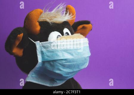 Lustiges Plüschspielzeug in einer blauen Schutzmaske Stockfoto
