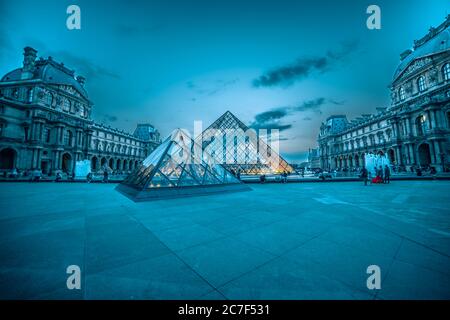 Glaspyramide des Louvre unter dem nebligen Blau und Rosa Himmel vervollständigt die Szenerie des Pariser Abends Stockfoto