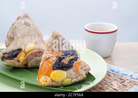 Reisknödel oder Zongzi ist ein traditionelles chinesisches Essen, das aus klejeweidem Reis mit verschiedenen Füllungen gefüllt und in Bambus- oder Schilfblätter verpackt wird. T Stockfoto