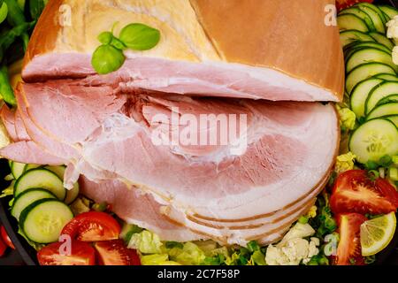 Schinken in Scheiben mit frischem Salat aus nächster Nähe. Draufsicht. Stockfoto