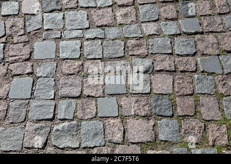 Textur, Hintergrund. Der Gehweg ist aus Granitstein. Alte Pflastersteinstraße Oberflächenstruktur, kein Gras zwischen Steinen. Hochwertige Fotos Stockfoto