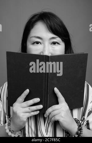 Portrait von reifen schönen asiatischen Geschäftsfrau mit Buch Stockfoto