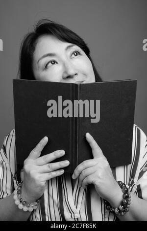 Portrait von reifen schönen asiatischen Geschäftsfrau mit Buch Stockfoto
