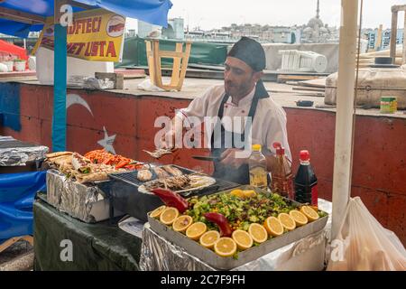 Man verkauft gegrillten Fisch an einem Stand, Fischmarkt, Karakoey, Istanbul, Türkei Stockfoto