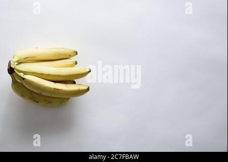 High-Angle-Schuss von frischen leckeren Bananen auf einem weißen Fläche mit leerem Leerzeichen für Text Stockfoto