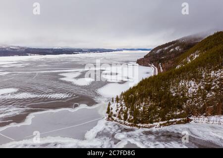 Landschaft eines gefrorenen Sees, umgeben von schneebedeckten Bergen in Lappland, Schweden Stockfoto