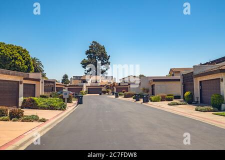 Wohnanlagen mit Garage auf der Vorderseite und Mülltonnen auf der Straße in einer kleinen Stadt in Kalifornien Stockfoto