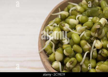 Gekeimt Mungbohnen in einer Holzschale. Makroaufnahme. Konzept von Microgreen Stockfoto