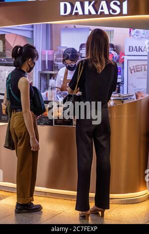 Kunden und Mitarbeiter im Café tragen Gesichtsmasken während covid 19 Pandemie, Bangkok, Thailand Stockfoto