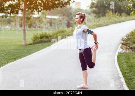Sportliche Frau joggt im leeren Park durch soziale Distanzierungsmaßnahmen Stockfoto
