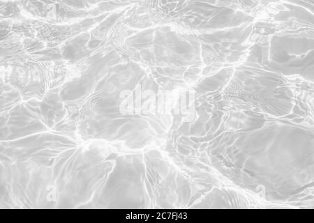 Nahaufnahme der entsättigte transparente klare ruhige Wasseroberfläche Textur mit Spritzern und Blasen. Trendy abstrakt Natur Hintergrund. Stockfoto