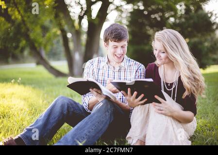 Weißes christliches Paar genießt das Lesen der Bibel in der Mitte Eines Feldes Stockfoto