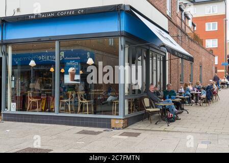 Leute sitzen an Pflastertischen, geselligen sich und genießen Erfrischungen im Cafe Nero Café, High Street, Rickmansworth, Hertfordshire, England Stockfoto