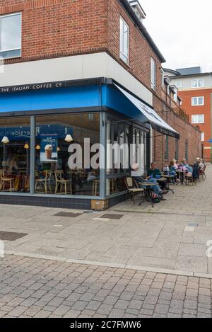 Leute sitzen an Pflastertischen, geselligen sich und genießen Erfrischungen im Cafe Nero Café, High Street, Rickmansworth, Hertfordshire, England Stockfoto