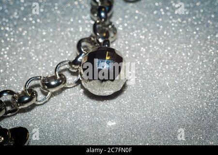 Mode Armband mit silbernen Charms auf Glitzer-Hintergrund. Stockfoto