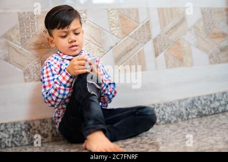 Indoor-Bild von kleinen Jungen mit Smartphone und spielen Videospiel in der Freizeit. Stockfoto