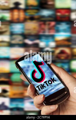 Hand hält ein Smartphone mit TikTok-Logo auf dem Bildschirm Stockfoto