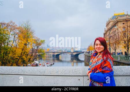 Eine rothaarige brasilianerin in ihren 20ern vor einer Brücke in Prag, Tschechien und lächelnd zur Kamera. Stockfoto