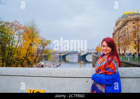 Eine rothaarige brasilianerin in ihren 20ern vor einer Brücke in Prag, Tschechien und lächelnd zur Kamera. Stockfoto