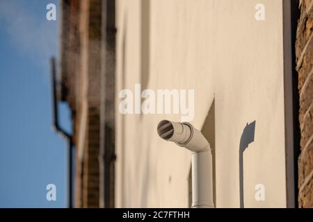 Detailansicht eines neu installierten Dampfventilatorrohrs, das an einem Kondensatorkessel in einem Privathaus angeschlossen ist. Stockfoto