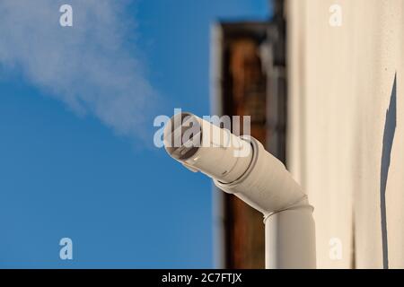 Detailansicht eines neu installierten Dampfventilatorrohrs, das an einem Kondensatorkessel in einem Privathaus angeschlossen ist. Stockfoto