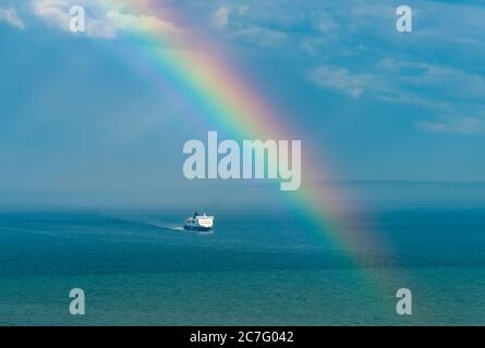 Eine Fähre, die den Ärmelkanal unter Regenbogen überquert; von den Klippen bei Dover genommen. Stockfoto