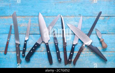 Sammlung von Küchenmesser, flach auf rustikalem Tisch liegen Stockfoto