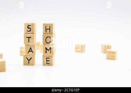 Ein Wort bleibt zu Hause geschrieben auf den Holzwürfeln. Stay Home Schriftzug aus Holzwürfeln isoliert auf Weiß Stockfoto