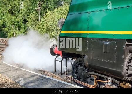 Nahaufnahme einer restaurierten britischen Dampflokomotive, die die Vorderseite des Motors zeigt, die während einer Station von Kesseldampf abgelassen werden kann. Stockfoto