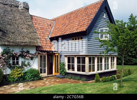 Ein Wetterverlängerungsbau auf einem traditionellen Norfolk-Reethäuschen. Stockfoto