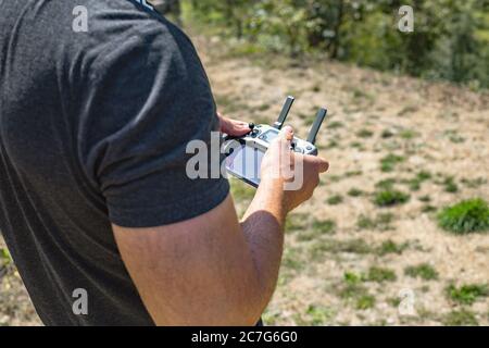 Mann, der eine Drohne mit Fernbedienung betreibt. Nahaufnahme. Selektiver Fokus. Stockfoto