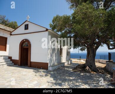 Die Kirche Agios Ioannis auf dem Mamma Mia Kliff auf der Insel Skopelos, erschüttert vom blauen Mittelmeer. Stockfoto