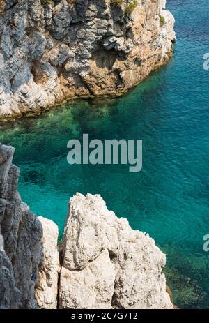 Die Sommersonne lädt das klare, klare, blaue und türkisfarbene Wasser zum Leuchten in einer Bucht der Insel Skopelos ein und Sie wollen sich zur Erfrischung einlassen. Stockfoto