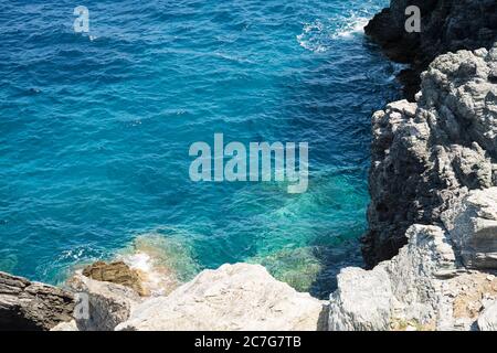 Die Sommersonne lädt das klare, klare, blaue und türkisfarbene Wasser zum Leuchten in einer Bucht der Insel Skopelos ein und Sie wollen sich zur Erfrischung einlassen. Stockfoto