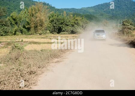 Eine Staubstraße im Dorf Huay Xai in Lao am Mekong-Fluss aus der Sicht im Nordwesten Laos in Lao. Lao, Huay Xay, November 2019 Stockfoto