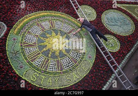 David Dorward vom Edinburgh Council Botanical Services nimmt letzte Anpassungen bei der Enthüllung von Edinburghs weltberühmter Blumenuhr in Princes Street Gardens, Edinburgh, die dem NHS und Schlüsselarbeitern Tribut zollt, vor. Stockfoto