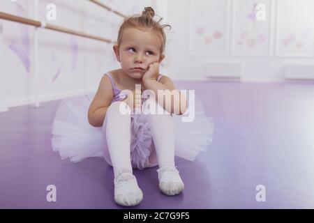 Nette kleine lustige Ballerina Mädchen mit verärgerten Ausdruck wegschauen, kopieren Raum. Liebenswert kleine Ballerina sieht müde und gelangweilt in der Ballettklasse. Stockfoto