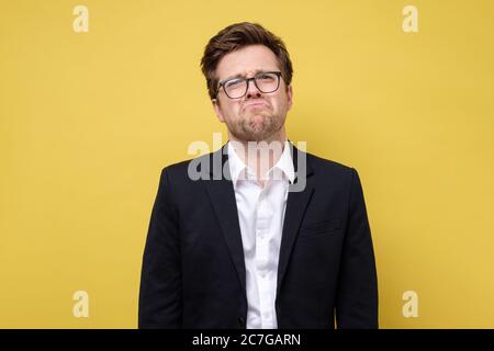 Junger kaukasischer Geschäftsmann runzelte das Gesicht vor Unmut Stockfoto
