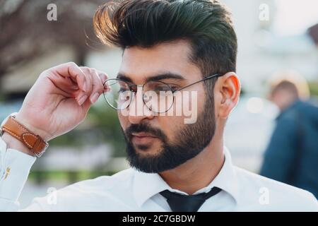 Stilvoll gekleideter indischer Bärtiger geht die Straße hinunter. Stockfoto