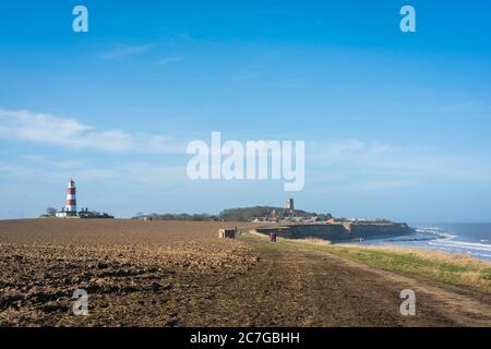 Happisburgh Norfolk, Blick auf Menschen, die auf dem North Norfolk Coastal Path am Happisburgh Beach, Norfolk, England, Großbritannien, wandern Stockfoto