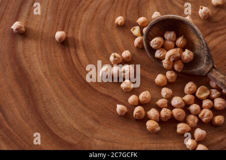 Superfood Kichererbsen liegen in Holzhintergrund mit Löffel. Nahaufnahme. Draufsicht. Stockfoto