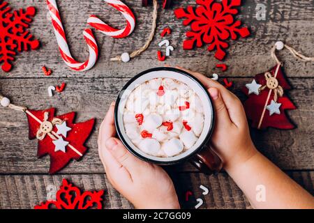 Frau Mädchen Hält Heiße Schokolade Tasse. Weihnachtskarte Mit Roter Dekoration. Thema Neujahr. Weihnachts Tradition Getränk auf Holz Hintergrund Tisch Stockfoto