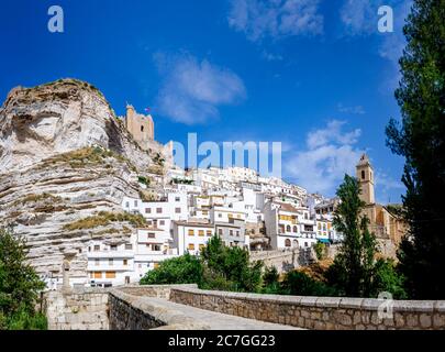 Blick auf die spanische Touristenstadt Alcala del Jucar, mit ihrem Schloss und weißen Häusern von der mittelalterlichen Brücke. Stockfoto