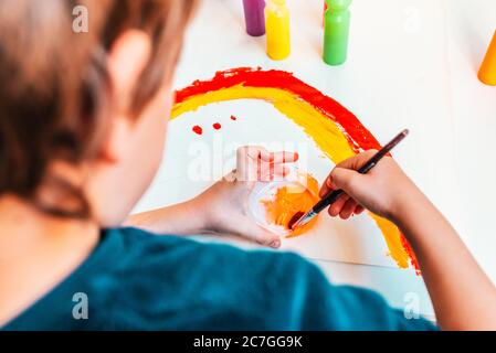 Pinselstriche eines Jungen mit Acrylfarbe auf Papier in seiner Schule. Stockfoto