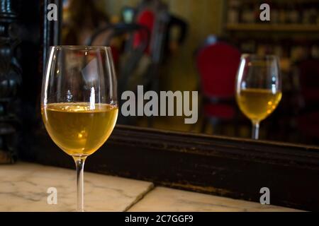 Ein volles Weißweinglas auf dem Tisch, Weinflasche Hintergrund, Weinmagazin und Shop im Restaurant und Bar. Georgische Wein in Tiflis. Stockfoto