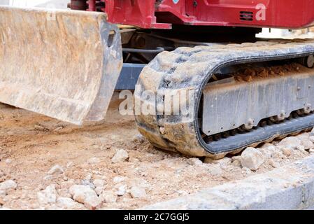 Caterpillar Räder eines Baggers auf Felsen auf einer Baustelle. Stockfoto