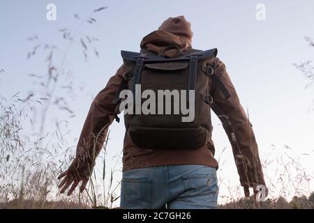 Mann auf einer Wanderung, der über ein Feld schaut. Rückansicht. Stockfoto