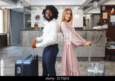 Konzept für Geschäftsreisen. Schwarze Männer und kaukasische Frauen Geschäftsleute Kollegen Check-in im Hotel Stockfoto