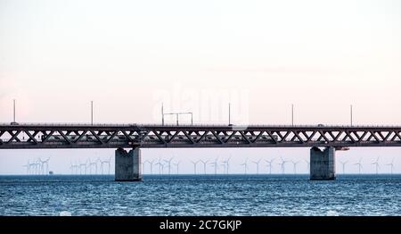 Schöne Aufnahme der Oresundbrücke über das Wasser mit Windmühlen in der Ferne Stockfoto