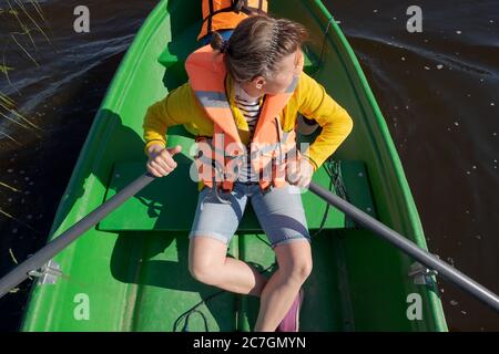 Frau, die an sonnigen Tagen ein Boot durch den Fluss paddelt Stockfoto